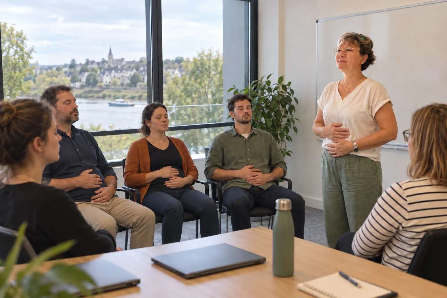 Atelier de sophrologie en entreprise, équipe assise en salle de réunion